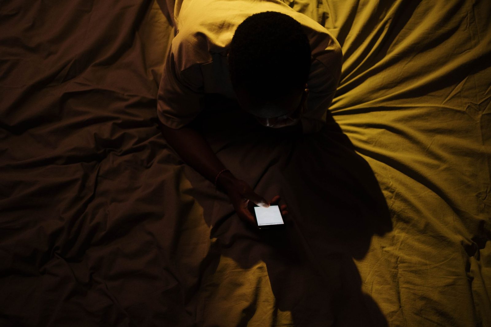 A lit phone screen in a dark bedroom late at night