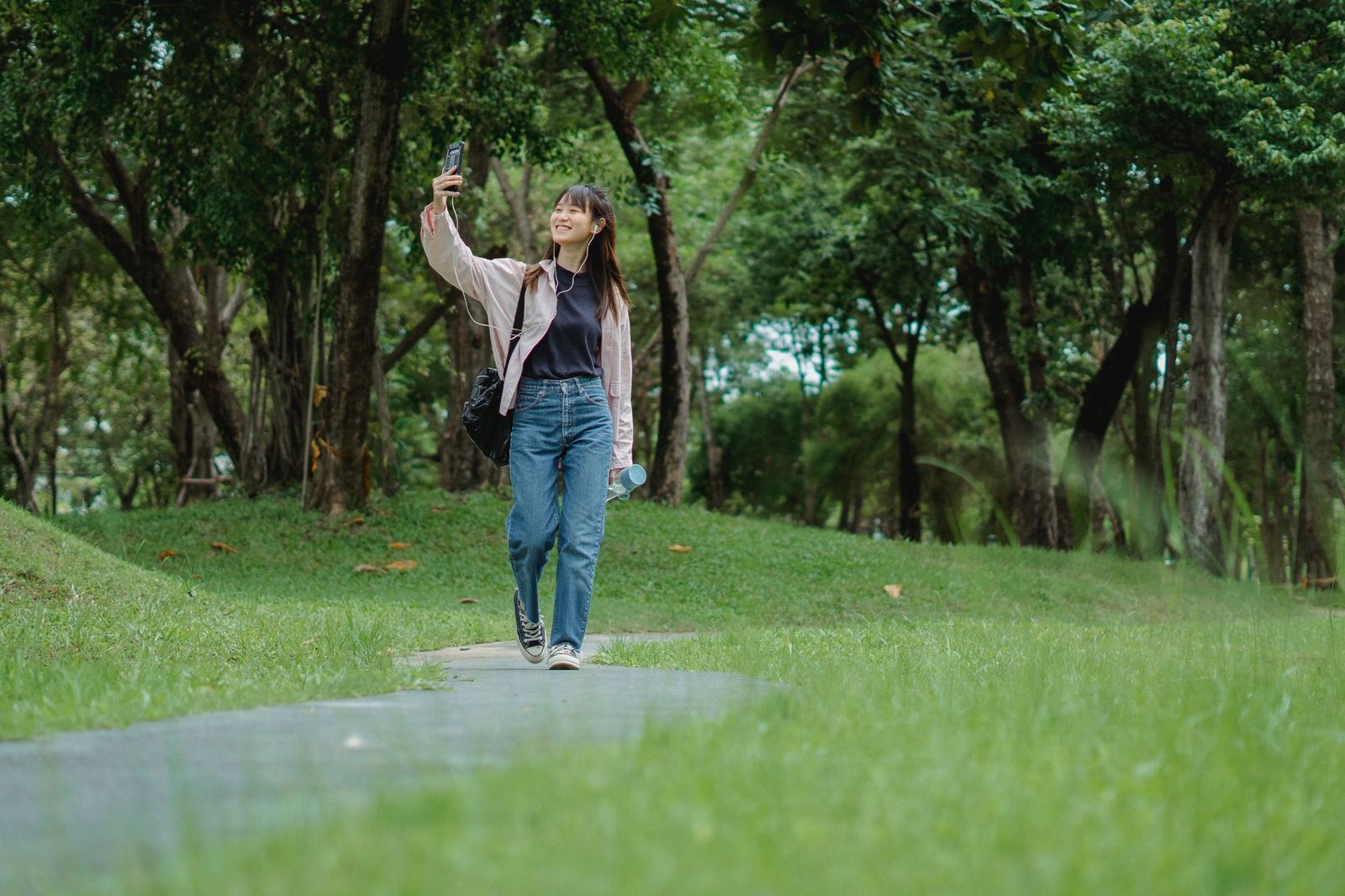 a woman in her thirties walking outside in daylight, exhaling, no phone in hand || woman her thirties walking outside exhaling phone hand