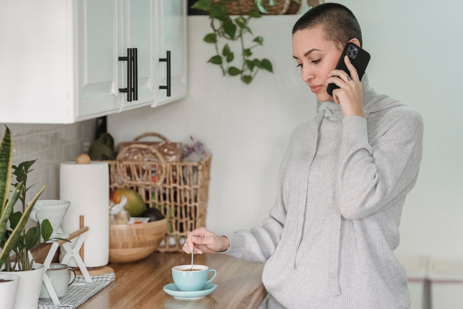 woman her sitting kitchen counter phone face down next coffee mug looking thoughtful scene and domestic sec couple their sitting couch one leaning mid conversation one laughing sec woman walking outside jacket hands pockets expression not model staged thirties