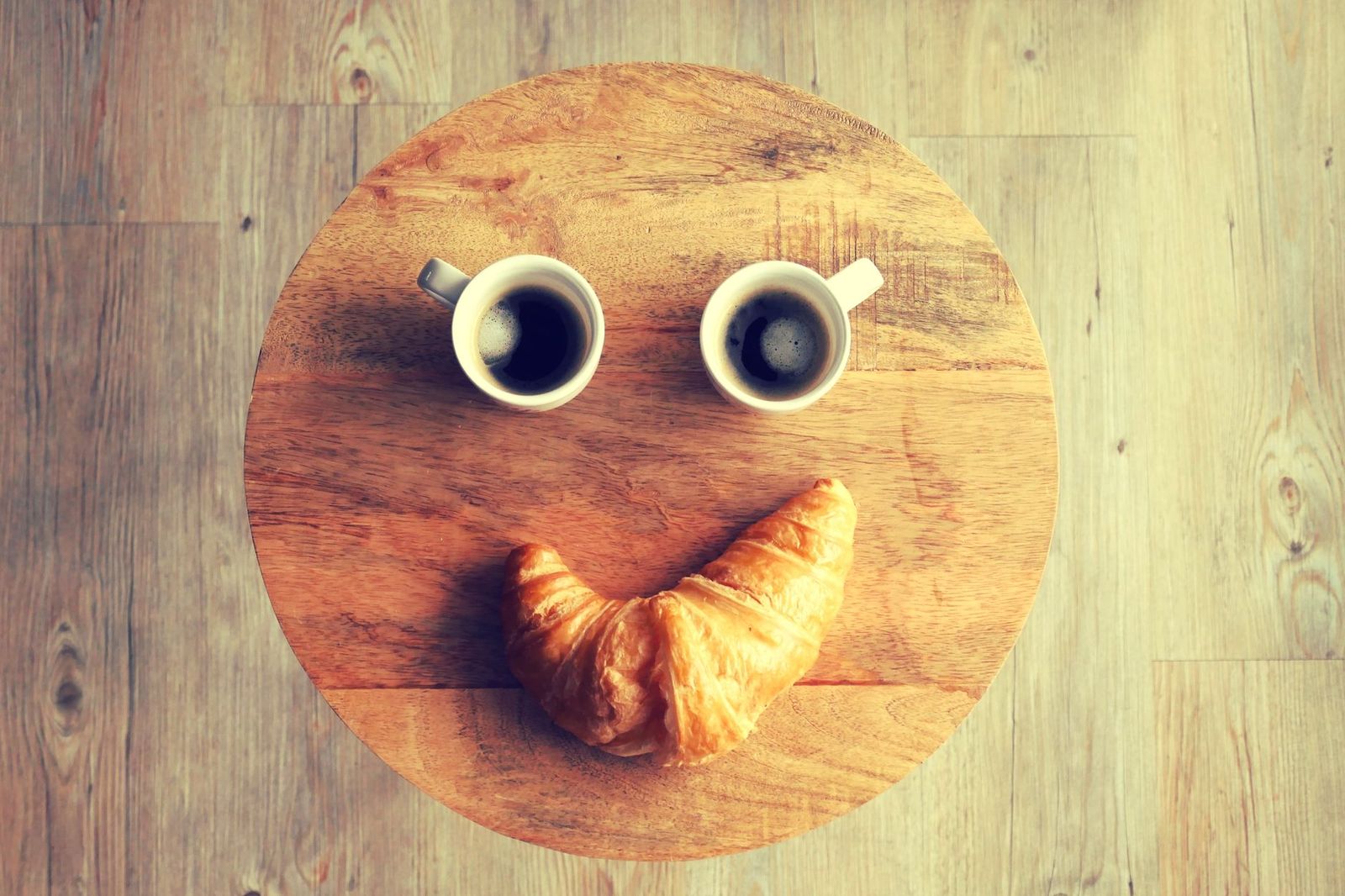 two coffee cups on a small table with a phone face down, morning light || two coffee cups table with phone face down light