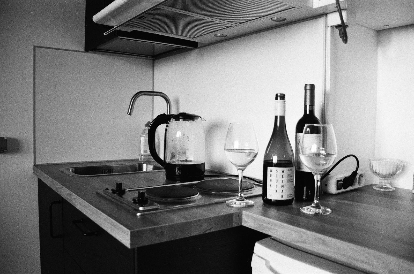 woman her late thirties kitchen counter after midnight phone face down beside half finished glass red wine keys and jacket the counter