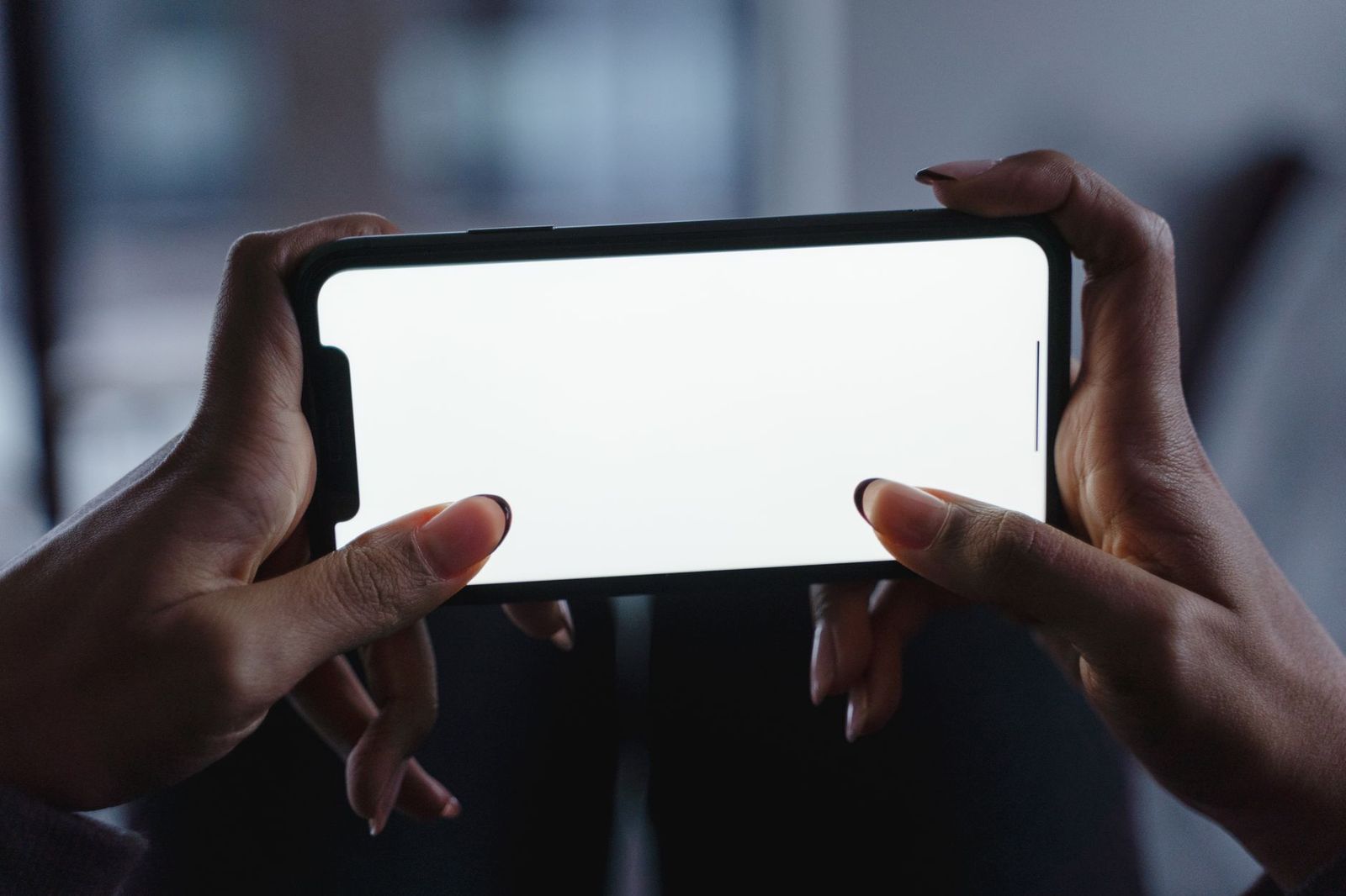 a hand holding a phone with a delete-app confirmation dialog on screen, thumb hovering || hand holding phone with delete app confirmation dialog screen thumb hovering
