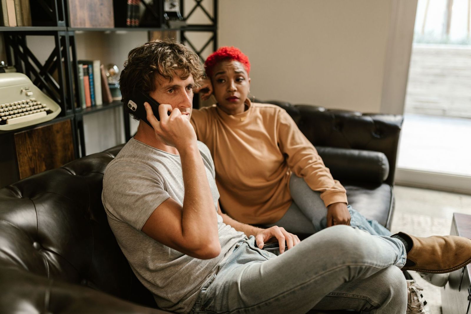woman her mid thirties sofa home phone hand mid conversation half finished coffee the table must show she's engaged not posed
