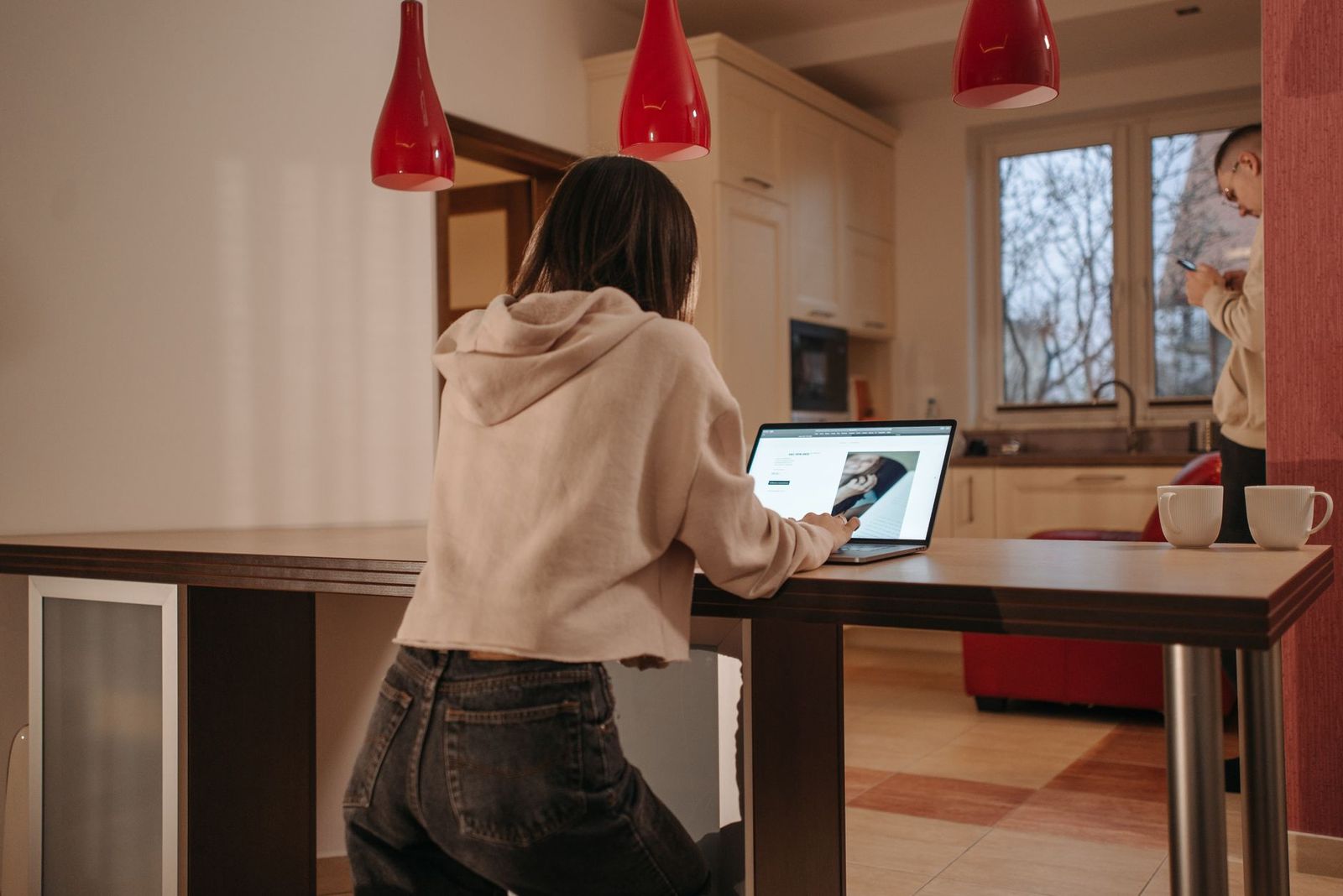 a kitchen table in morning light with two coffee cups and a closed laptop, no people || kitchen table light with two coffee cups and closed laptop people thirties