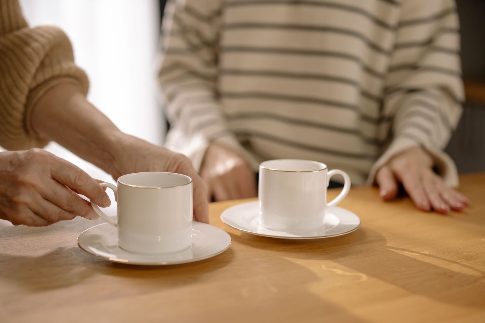 two coffee cups on a table, one half-full, the other untouched, morning light || two coffee cups table one half full the other untouched light