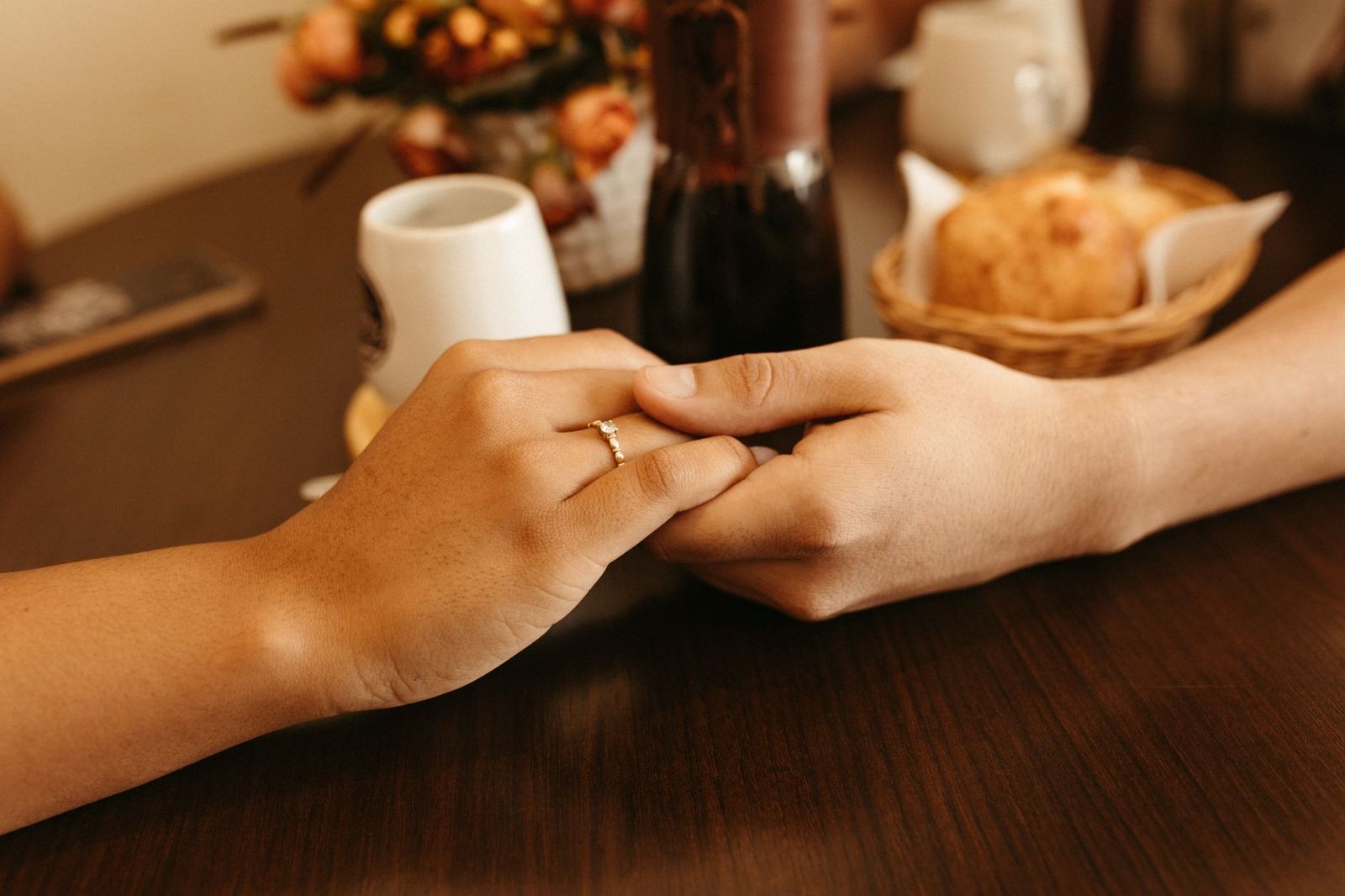 woman mid sitting kitchen table both hands wrapped around mug wedding ring the table front her alternatives chair pushed back door partially open thirties