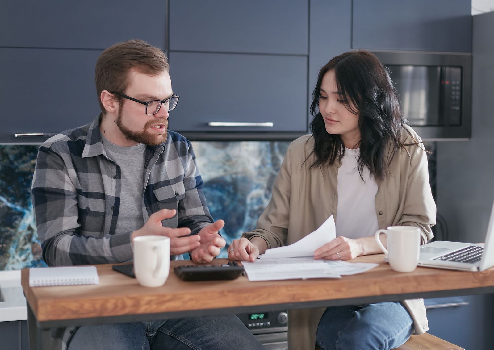 couple mid sitting kitchen table late thirties
