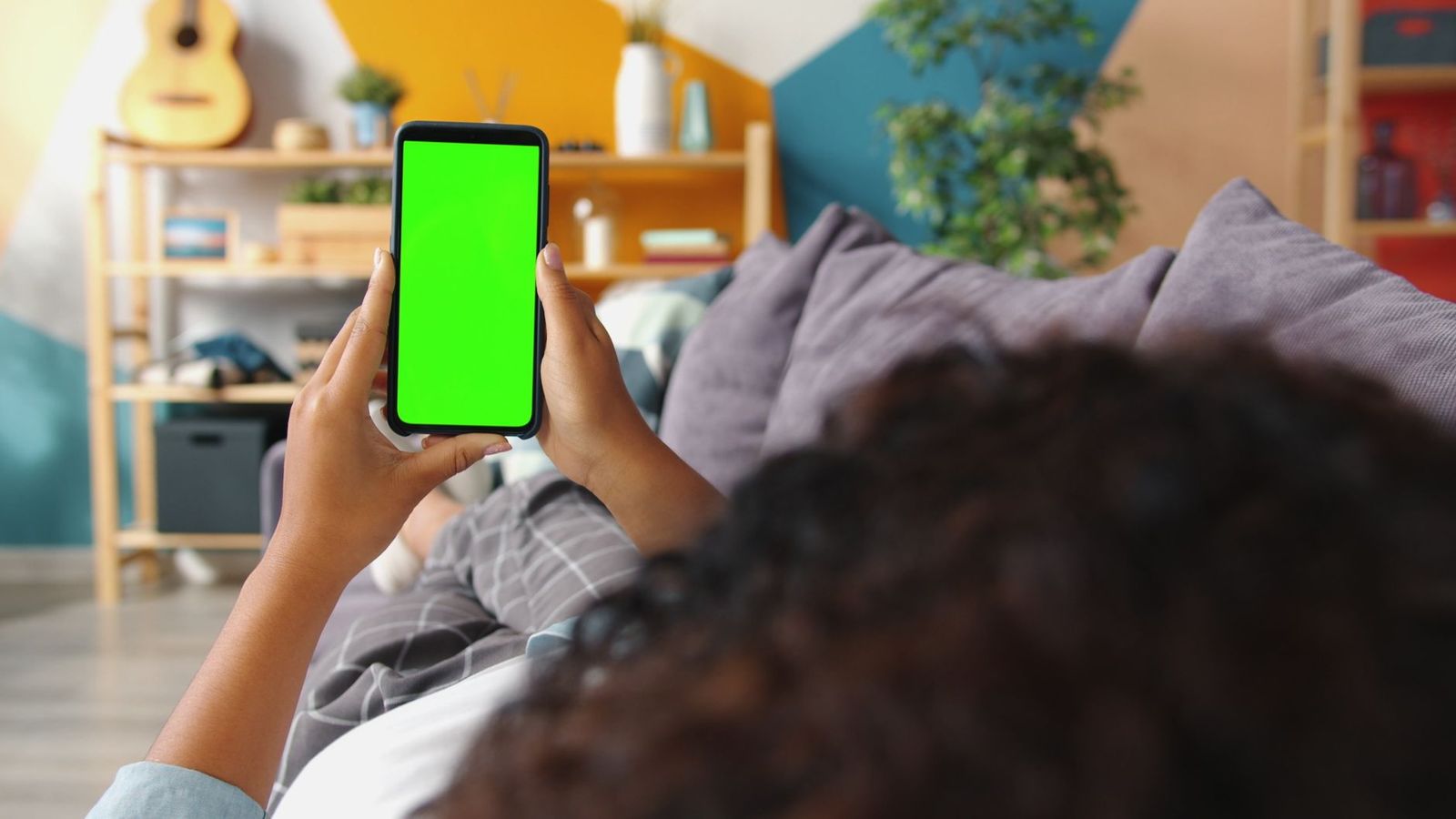 hero woman her early sitting alone couch living room holding phone looking the screen with expression off background thirties