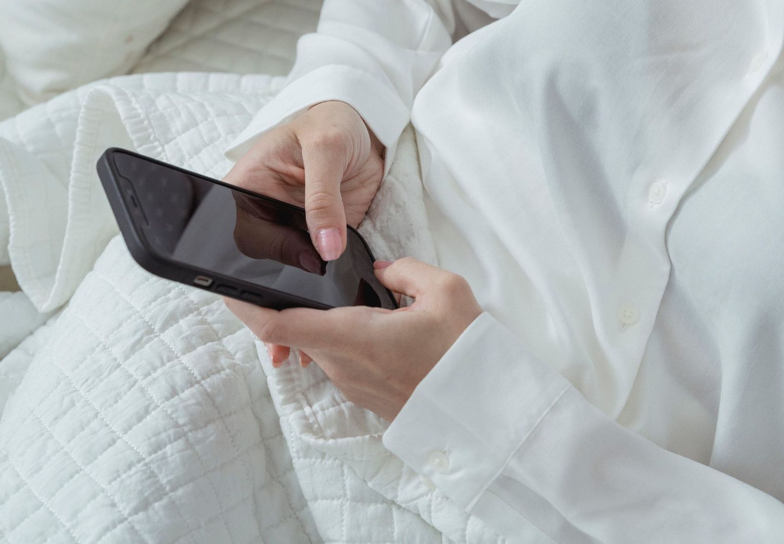 woman her thirties sitting the edge bed phone hand not looking man